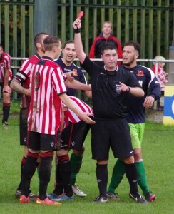 Referee Paul Tomes sends Worsbrough striker Brad Kerr off while Selby's Nathan Kamara watches on