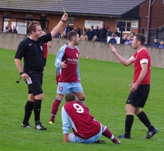 Matt Plant receives a yellow card after bringing down Ash Flynn