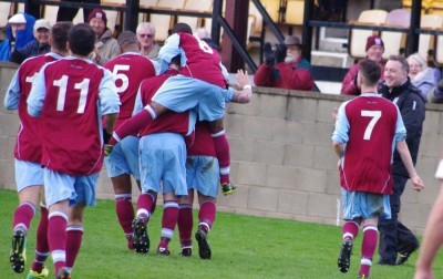 Emley celebrate in front of Darren Hepworth after Mickey Starkey's goal