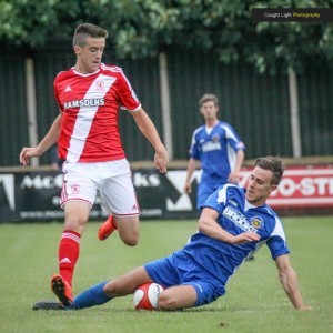 Defender Alex Low makes a tackle during Harrogate Railway's defeat to Middlesbrough. Picture: Caught Light Photography