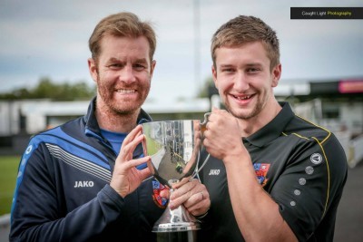 Harrogate Town manager Simon Weaver holds the John Smith's Trophy with a supporter