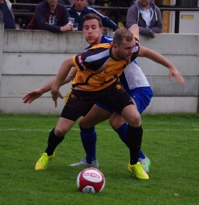 Ossett Albion striker Nicky Matthews holds off Alex Low 