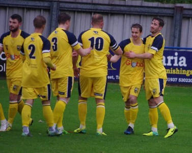 Adam Baker celebrates with his team-mates after scoring his second goal