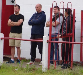 Selby Town manager Nigel Emery (second left) watched on from his usual unconventional position 