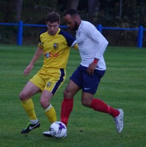 Ammers goal-scorer Joel Hughes takes on Andy Milne