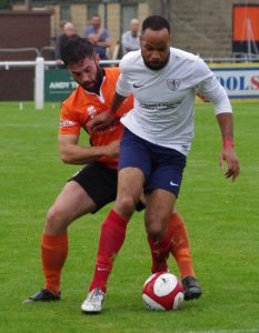 Yorkshire Amateur striker Joel Hughes holds off Sam Hewitt