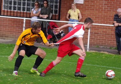 Handsworth left-back Connor Smythe holds Ben Rhodes' shirt