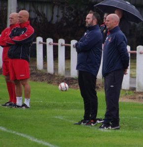 The two management teams watch from the sidelines 